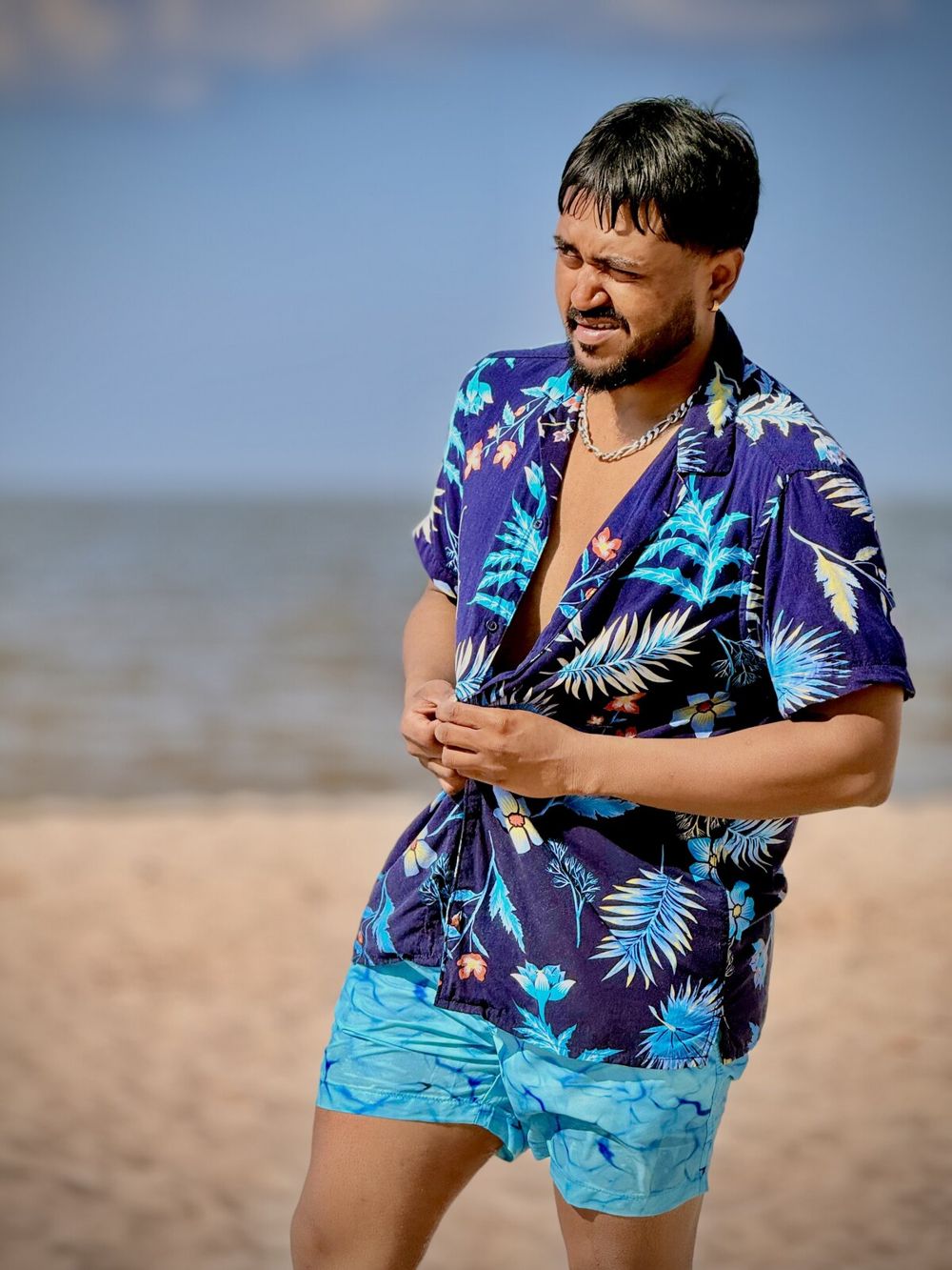 Hammer at the beach in a patterned shirt after his transformation